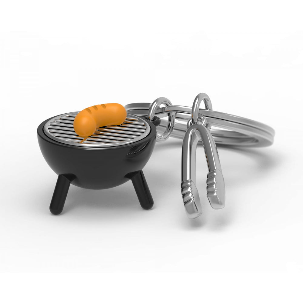 Oli Olsen BBQ keyring by Cornucopia Home and Gift featuring a miniature barbecue grill design on a metal keychain.