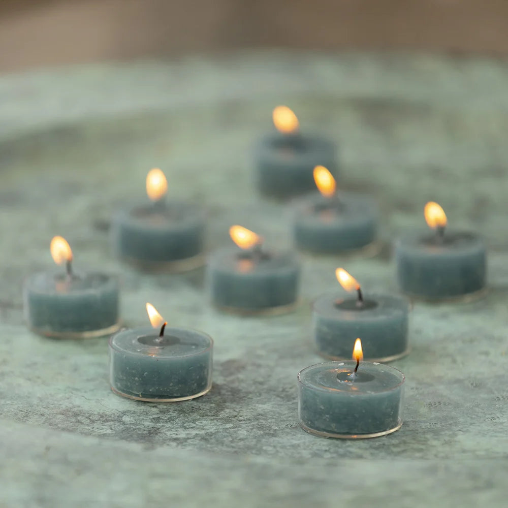 Rustic tealights in petrol blue from Grand Illusions by Cornucopia Worcester, shown in a natural setting with soft lighting.