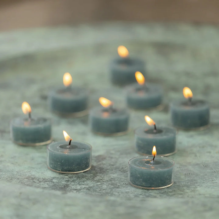 Rustic tealights in petrol blue from Grand Illusions by Cornucopia Worcester, shown in a natural setting with soft lighting.