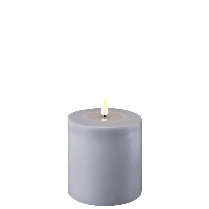 Dusty blue LED candle from Cornucopia Home and Gift's Deluxe Home Art collection, displayed with a soft glow in a cozy setting.
