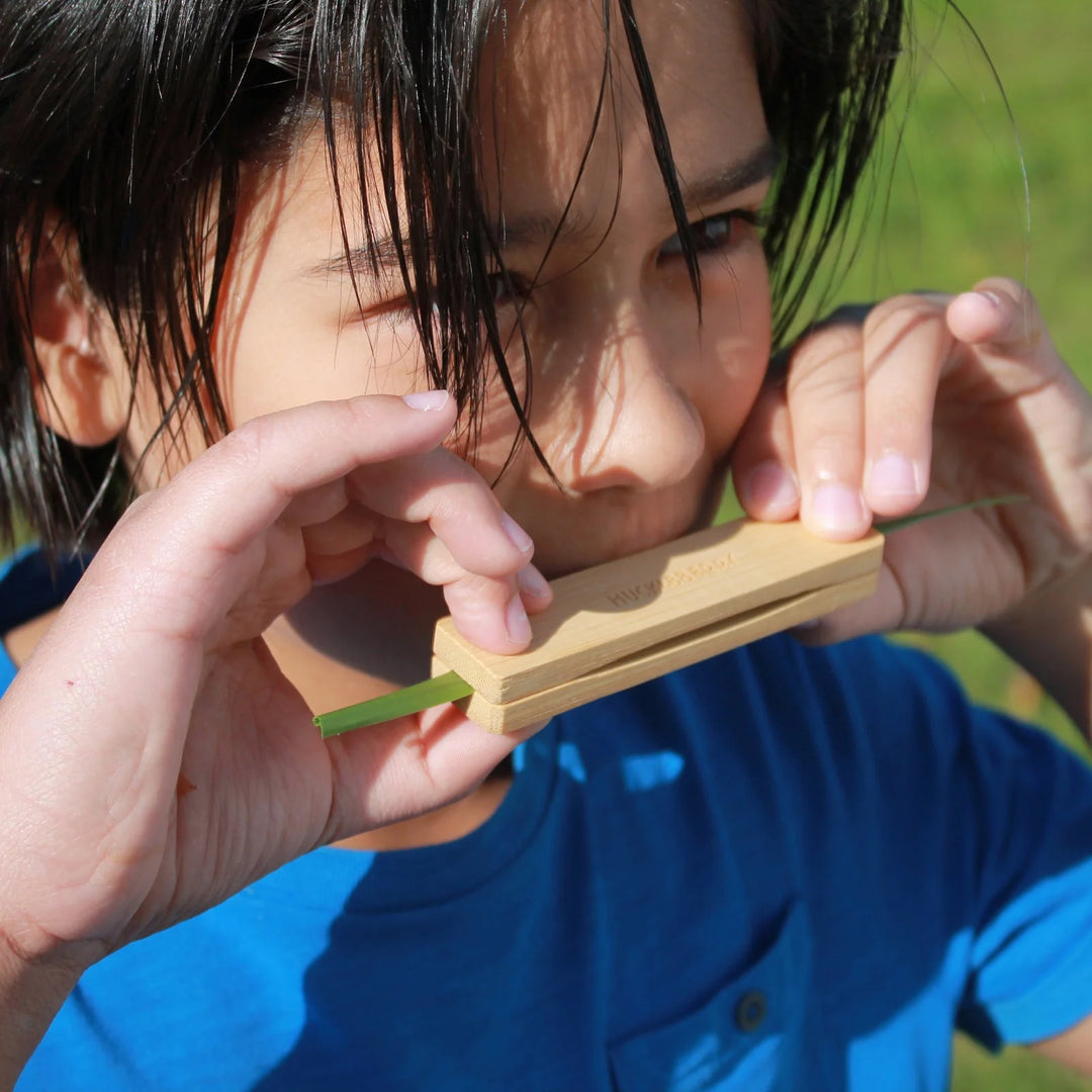 Kikkerland Huckleberry Grass Whistle made of natural grass with a small opening, designed for sound production and decorative display.