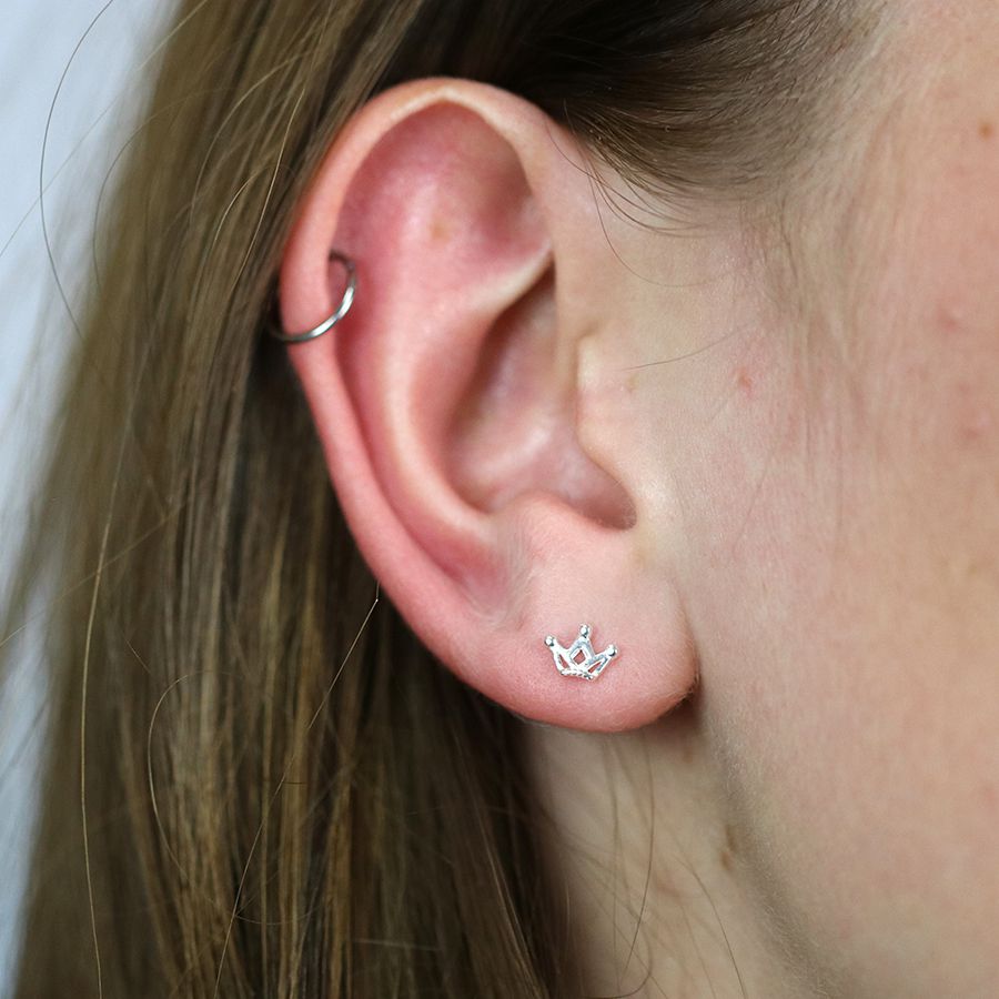 Tiny silver crown stud earrings by POM Jewellery from Cornucopia Worcester, featuring small crown designs on sterling silver studs.