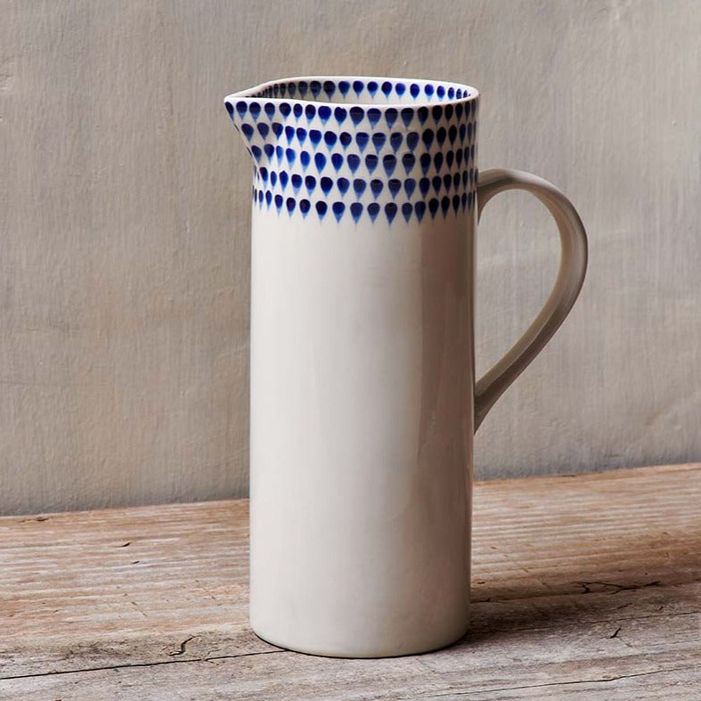 Indigo ceramic drop jug by Nkuku with a glossy finish, featuring a rounded body and narrow spout for pouring.