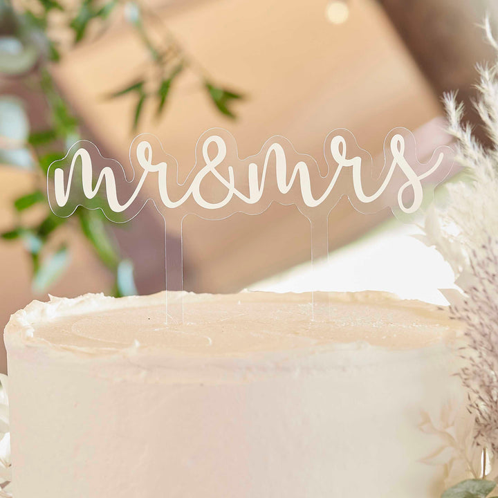 Ginger Ray Mr and Mrs acrylic cake topper with gold lettering on clear acrylic, ideal for wedding celebration cakes.